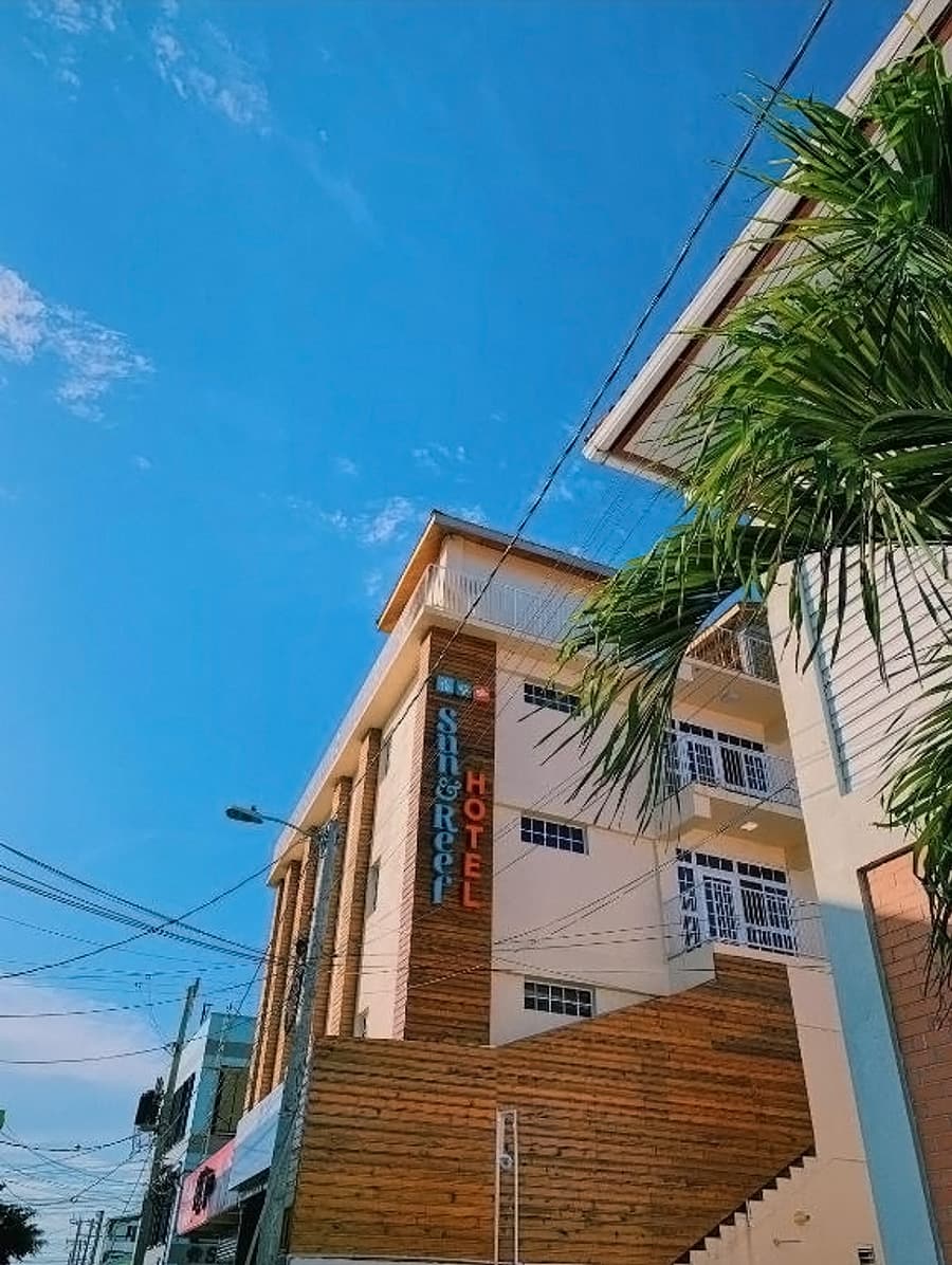 A hotel building with a wooden exterior under a clear blue sky.